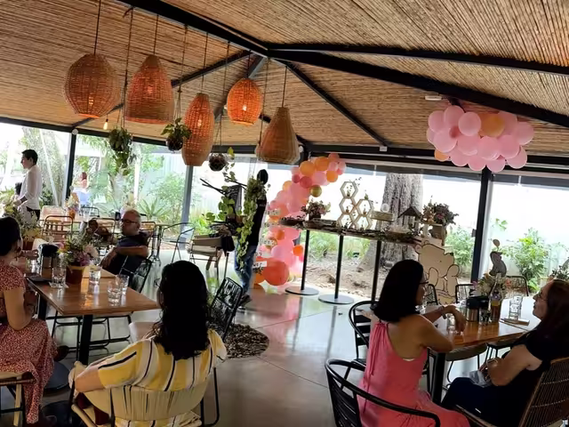 Una celebración en el salón de Wö Kàpi, con globos rosados y las mesas llenas